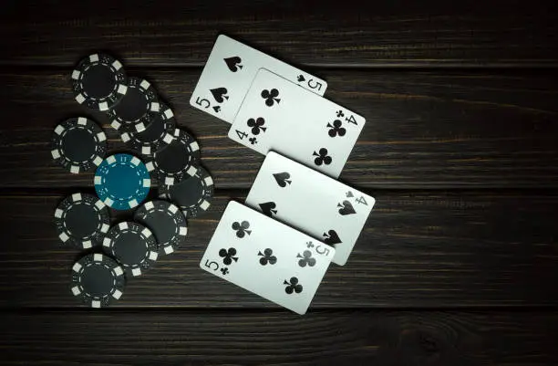 Photo of A popular poker game with a combination of two pairs. Chips and cards on a black vintage table in a poker club. Free space for advertising