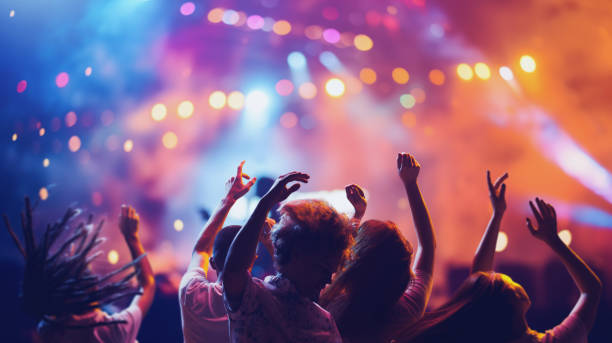 jovens felizes dançando, pulando e cantando durante show do grupo favorito. festival musical de verão. - festival de música - fotografias e filmes do acervo