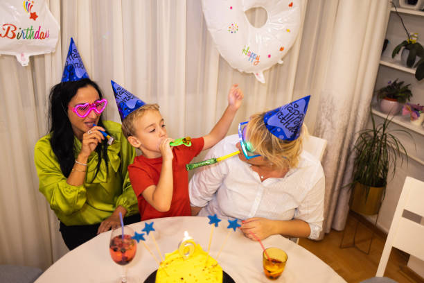 niño caucásico celebrando su 6º cumpleaños con su madre y su madrina - ahijado fotografías e imágenes de stock