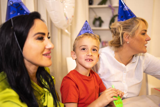 niño caucásico celebrando su cumpleaños con su madre y su tía - ahijado fotografías e imágenes de stock