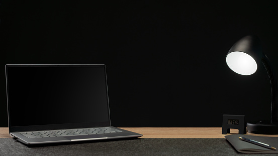 laptop and work equipment in office on black background