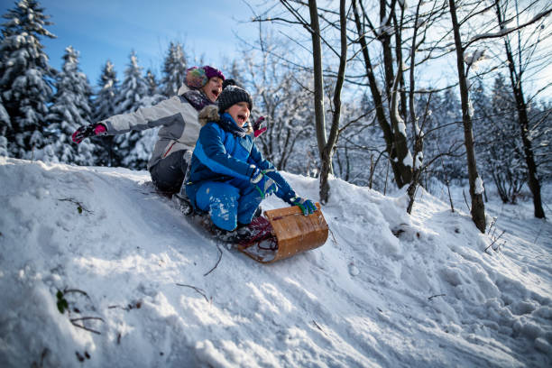 istock Kids enjoying tobogganing on winter evening. 1806033732