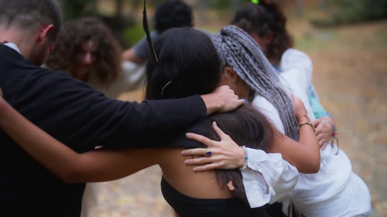 Multi-ethnic people gathering in nature for ecstatic dance event and dancing freely