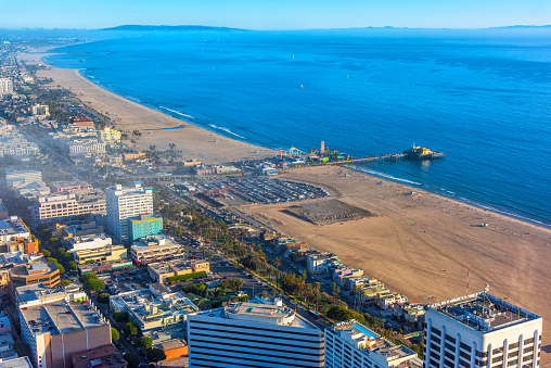 Aerial view of the city of Santa Monica with its beach and pier  shot via helicopter from an altitude of about 1000 feet near dusk.