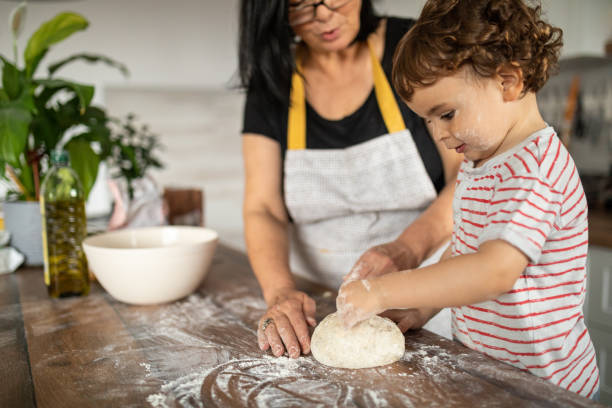 istock Little boy making bread with his grandma 1806050521