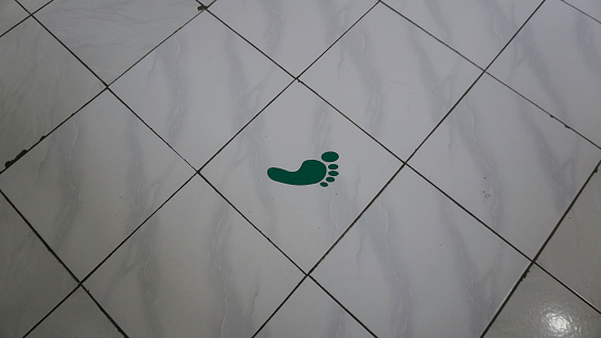 Green footprint sticker on the floor