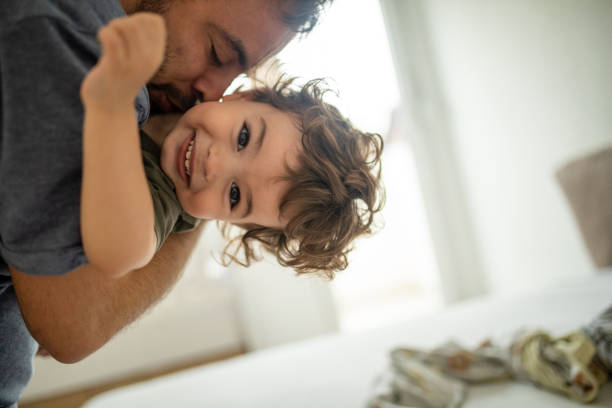 Young father and his toddler having the time of their lives Young father and his toddler having fun at home in the morning cute baby laughing stock pictures, royalty-free photos & images