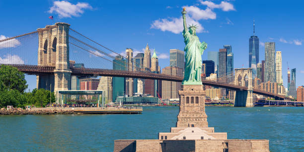 Statue of Liberty and New York City Skyline with Brooklyn Bridge, Manhattan High-Rises, World Trade Center and East River. stock photo