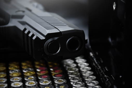 Man shooting handgun on black background, closeup