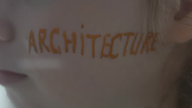 Serious cute little girl with Architecture inscription on her face. Architecture concept.
