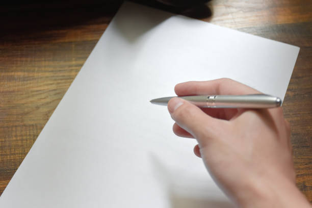 Hand writing with pen over blank paper on wooden work desk beautiful pattern,concept of idea and actions,Hand holding for pen,Work equipment in workplace,Hand close-up with pen and paper. escritura a mano con bolígrafo sobre papel en blanco sobre escritorio de trabajo de madera hermoso patrón, concepto de idea y acciones, mano sosteniendo para bolígrafo, equipo de trabajo en el lugar de trabajo, primer plano de la mano con bolígrafo y p