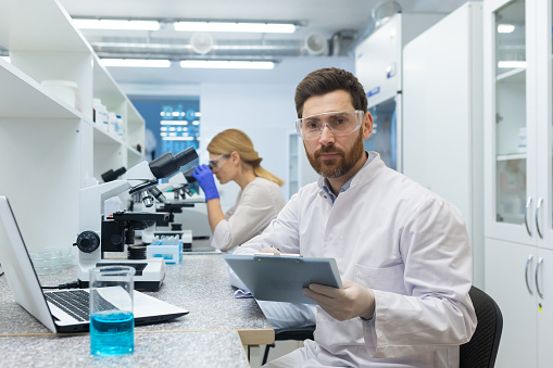 Portrait of smiling male scientist looking at results in laboratory