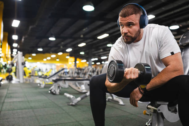 istock Handsome young man lifting weights in the gym 1806091456