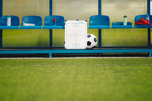 Soccer football strategy planning board and soccer ball. Coaching soccer. Coach having training with the team. Sports education. Sports abstract background