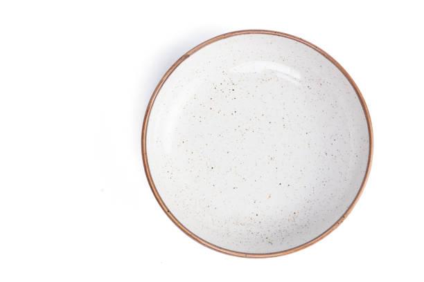 istock beige round ceramic plate with dotted isolated on a white background. top view 1806095242