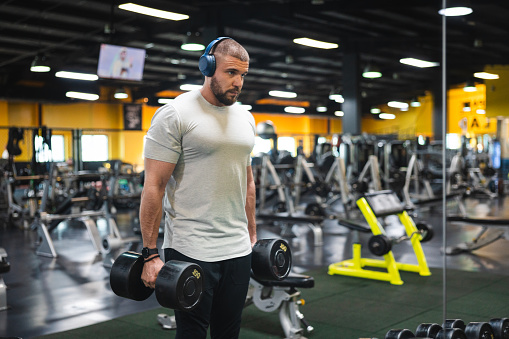 Handsome man listening to music while working out in the gym.