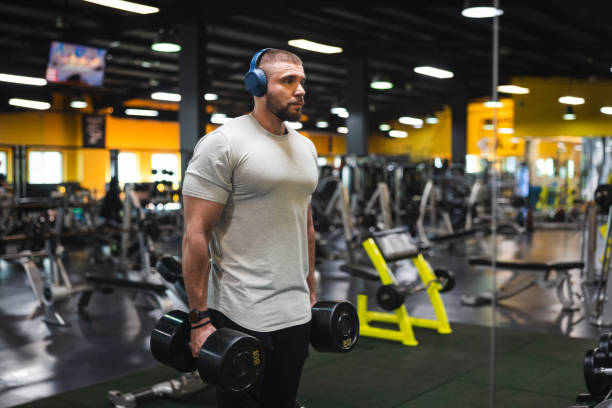 istock Young man lifting heavy weights in the gym 1806096343