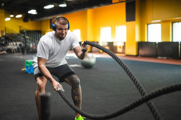 istock Young man working with ropes in the gym 1806097982