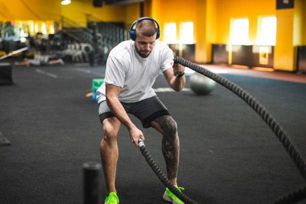 istock Young man working with ropes in the gym 1806098498