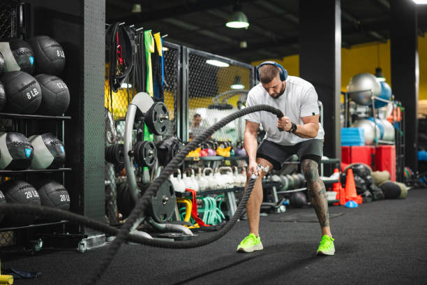 istock Young man working with ropes in the gym 1806098507