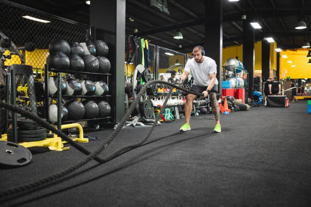 istock Young man working with ropes in the gym 1806099030