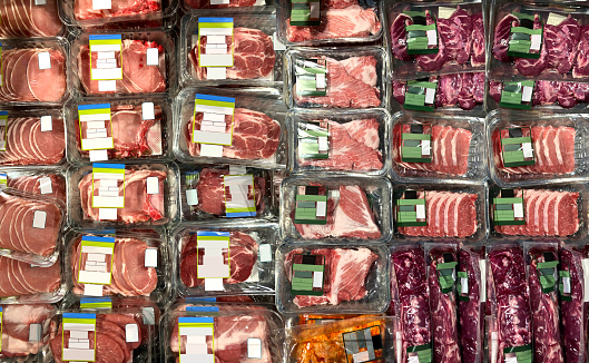 Steaks, Pork chops, ribeye at supermarket refrigerator. View from above. Brand-less packaging mockup and illustration ideal for graphic designers, architects and interior designers.