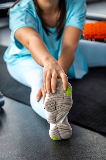 istock Woman stretching legs on exercise mat before training at gym. 1806133720