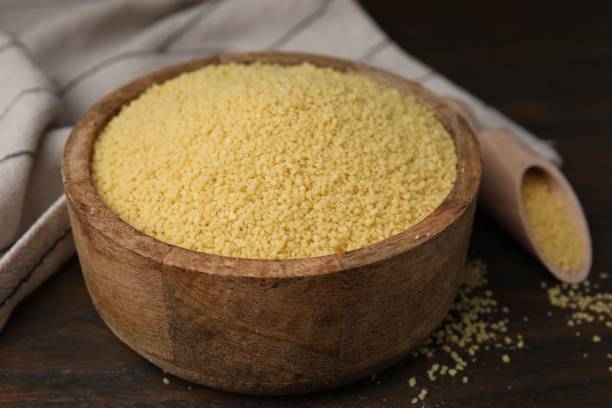 istock Raw couscous in bowl on wooden table, closeup 1806142525