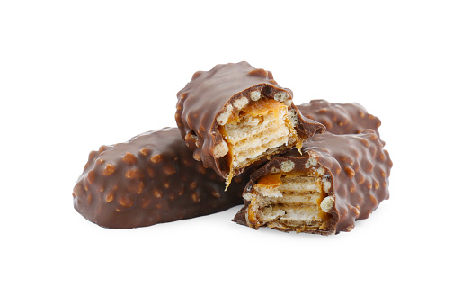 Pieces of chocolate bars with caramel on white background