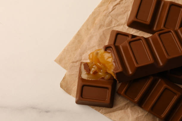 istock Tasty chocolate bars on white table, top view. Space for text 1806153594