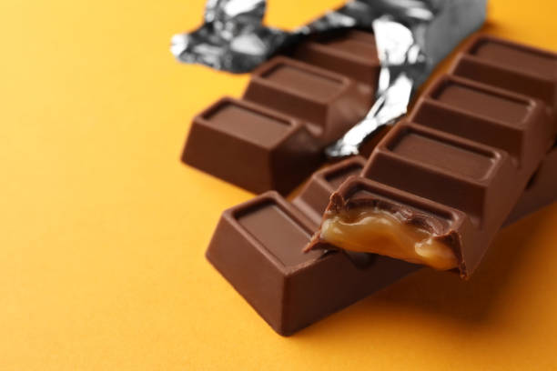 istock Tasty chocolate bars on yellow background, closeup. Space for text 1806154789