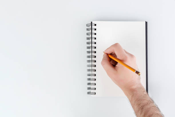 istock business notepad, hand holding a pencil on a white background 1806158098