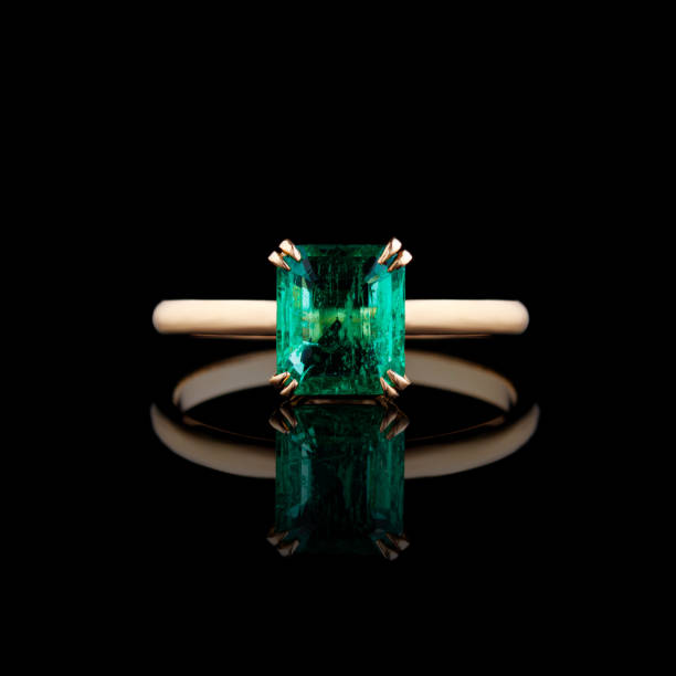 istock beautiful yellow gold ring with emerald on a black background 1806160246