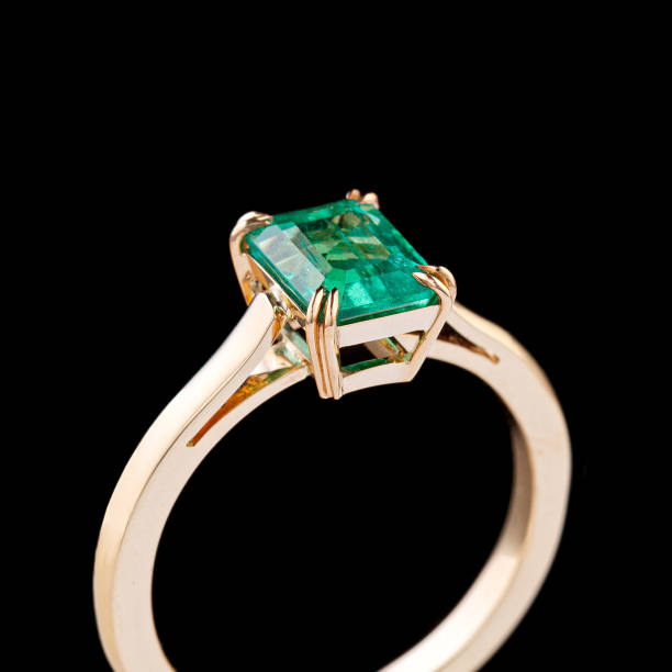 istock beautiful yellow gold ring with emerald on a black background 1806160765