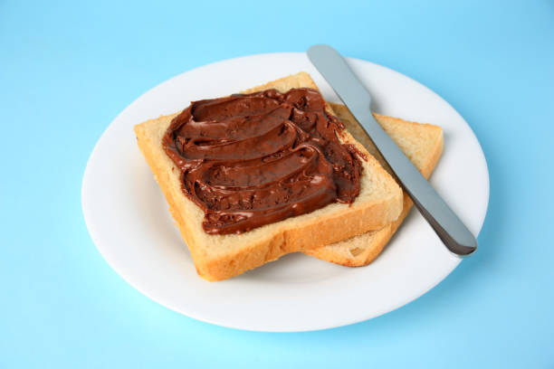istock Tasty toast with chocolate paste on light blue background 1806163520