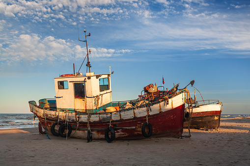 Early morning view of the old fishing ships on Jurmalciems beach near Liepaja in Latvia