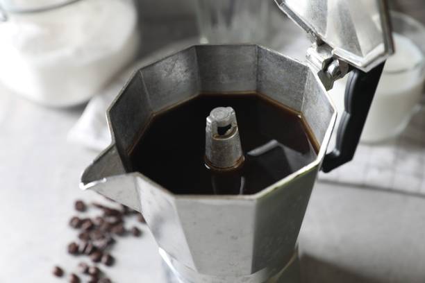 istock Brewed coffee in moka pot and beans on light grey table, closeup 1806166312
