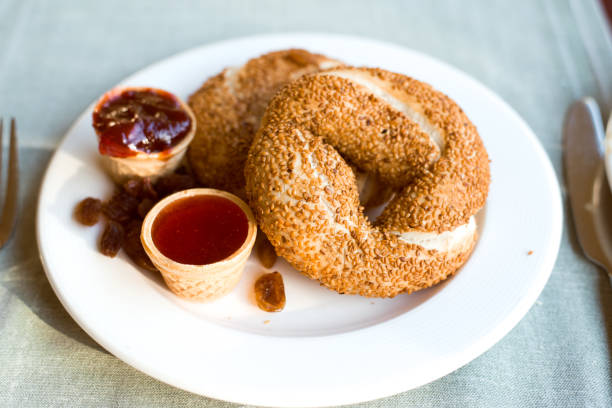 Turkish simit snack with sesame seeds on breakfast, jam and raisin topping
