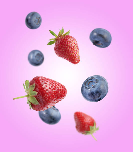istock Fresh ripe blueberries and strawberries falling on violet background 1806180510