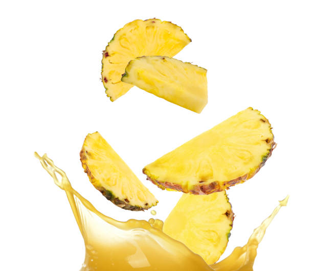 istock Pieces of ripe pineapple falling into juice on white background 1806181054