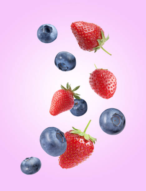 istock Fresh ripe blueberries and strawberries falling on violet background 1806181623