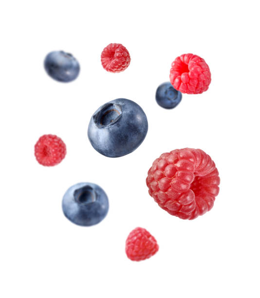 istock Fresh ripe blueberries and raspberries falling on white background 1806182179