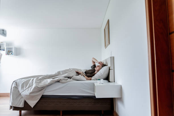 istock Depressed woman lying in her bed 1806182203