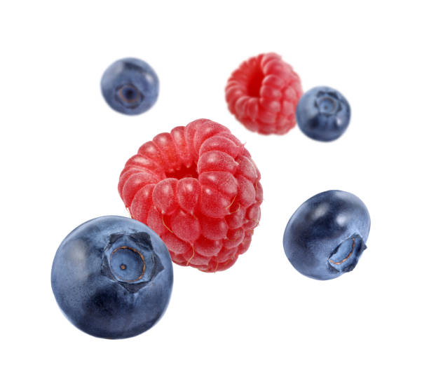 istock Fresh ripe blueberries and raspberries falling on white background 1806182755