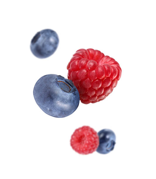 istock Fresh ripe blueberries and raspberries falling on white background 1806183331