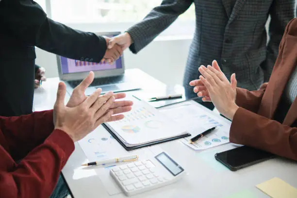 Photo of Businessmen and investors join hands symbolize friendship and cooperation in business success. concepts of group of businessmen and investors joining hands symbolize cooperation in doing business.