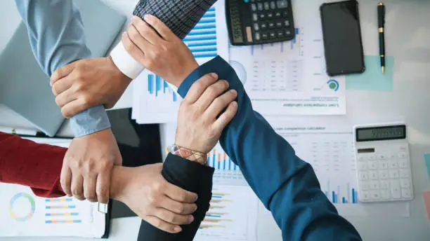 Photo of Businessmen and investors join hands symbolize friendship and cooperation in business success. concepts of group of businessmen and investors joining hands symbolize cooperation in doing business.