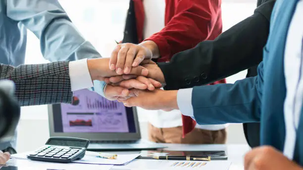 Photo of Businessmen and investors join hands symbolize friendship and cooperation in business success. concepts of group of businessmen and investors joining hands symbolize cooperation in doing business.