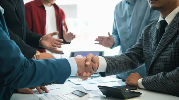 Photo of Businessmen and investors join hands symbolize friendship and cooperation in business success. concepts of group of businessmen and investors joining hands symbolize cooperation in doing business.