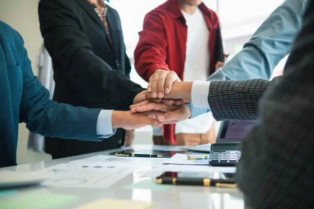 Photo of Businessmen and investors join hands symbolize friendship and cooperation in business success. concepts of group of businessmen and investors joining hands symbolize cooperation in doing business.